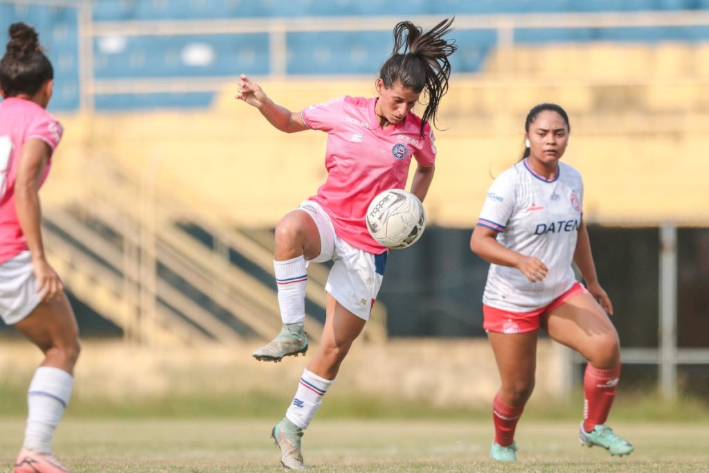 Time feminino do Bahia jogando com camisa rosa